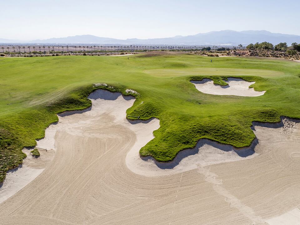Alhama Signature Golf green bordered by large sculpted sand bunkers