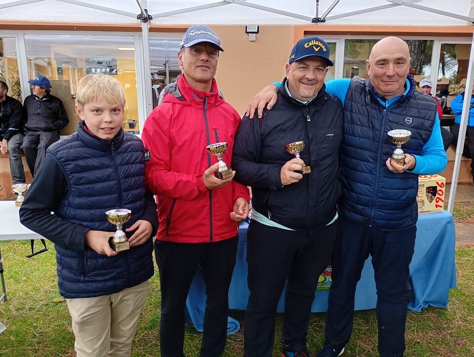 Four golf tournament winners pose with their trophies at Aldeamayor Club de Golf.