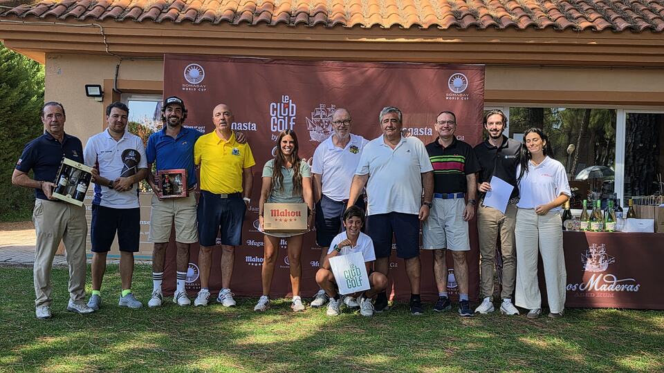 Participantes de un evento de golf posan con premios ante un panel en Aldeamayor Club de Golf.