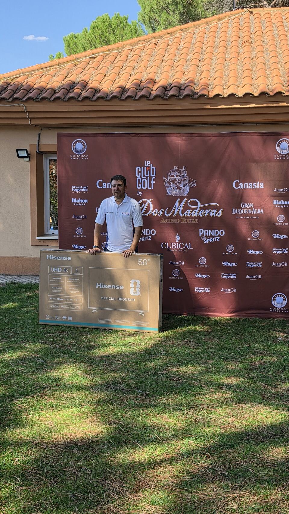 Un participante posa con un televisor Hisense delante del panel del torneo Ron 2 Maderas.