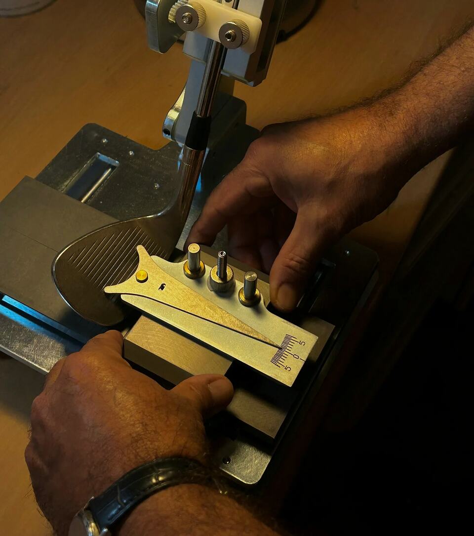 Hands adjusting a golf club head with a precision measuring tool