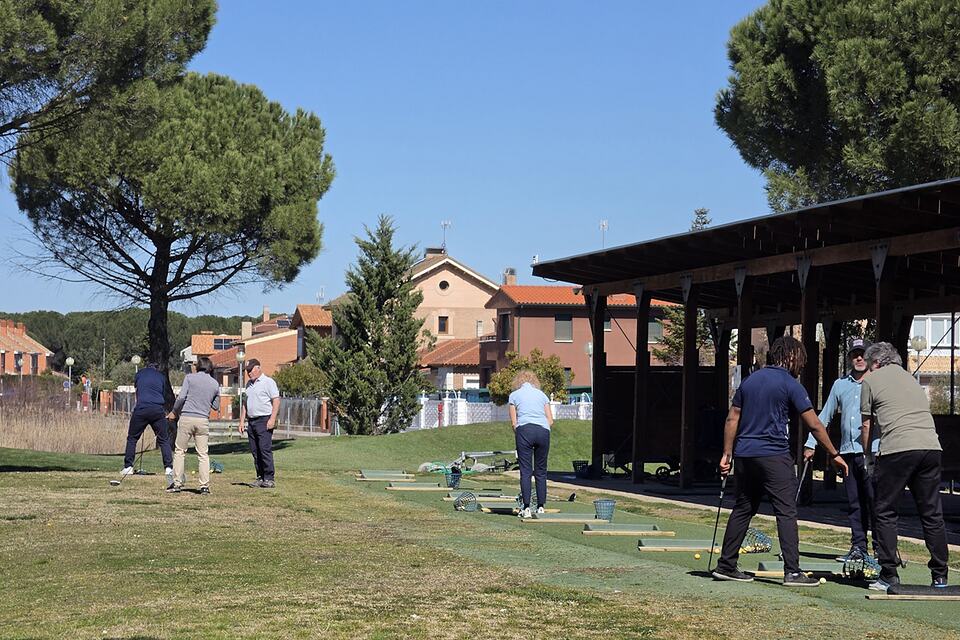 Golfers practising their swings on the driving range at Aldeamayor Club de Golf