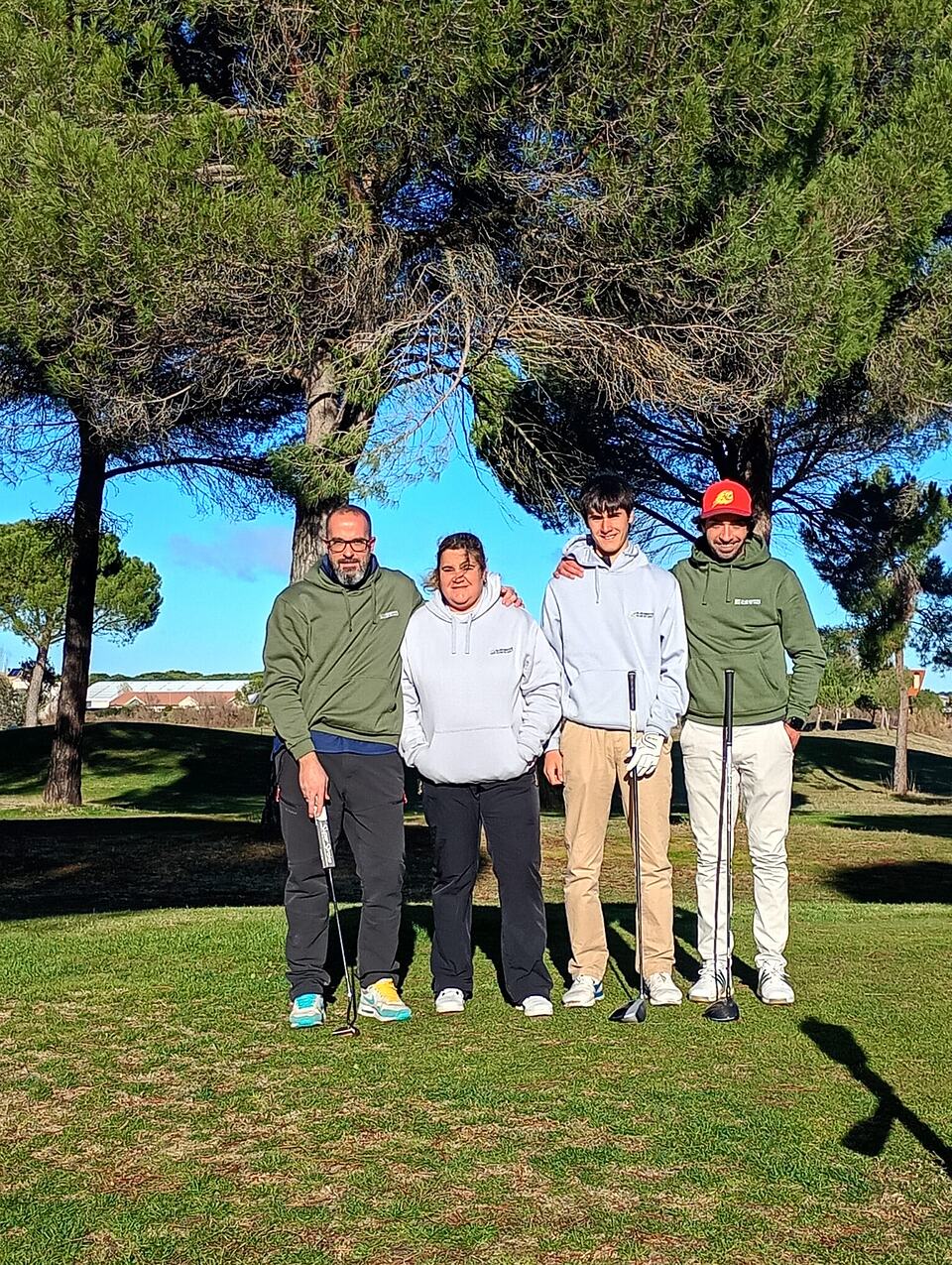 Four Ryder 2025 participants pose with golf clubs on the course at Aldeamayor Club de Golf.
