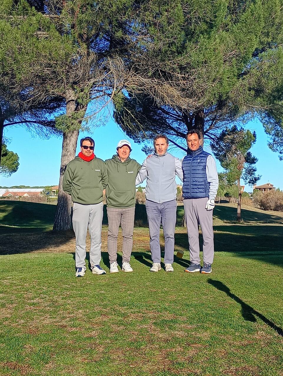 Four golfers pose together on the course during the 2025 Ryder event.