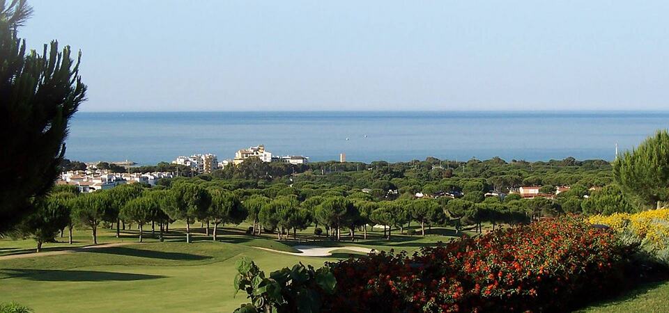 Cabopino golf course with pine trees and the Mediterranean Sea in the distance