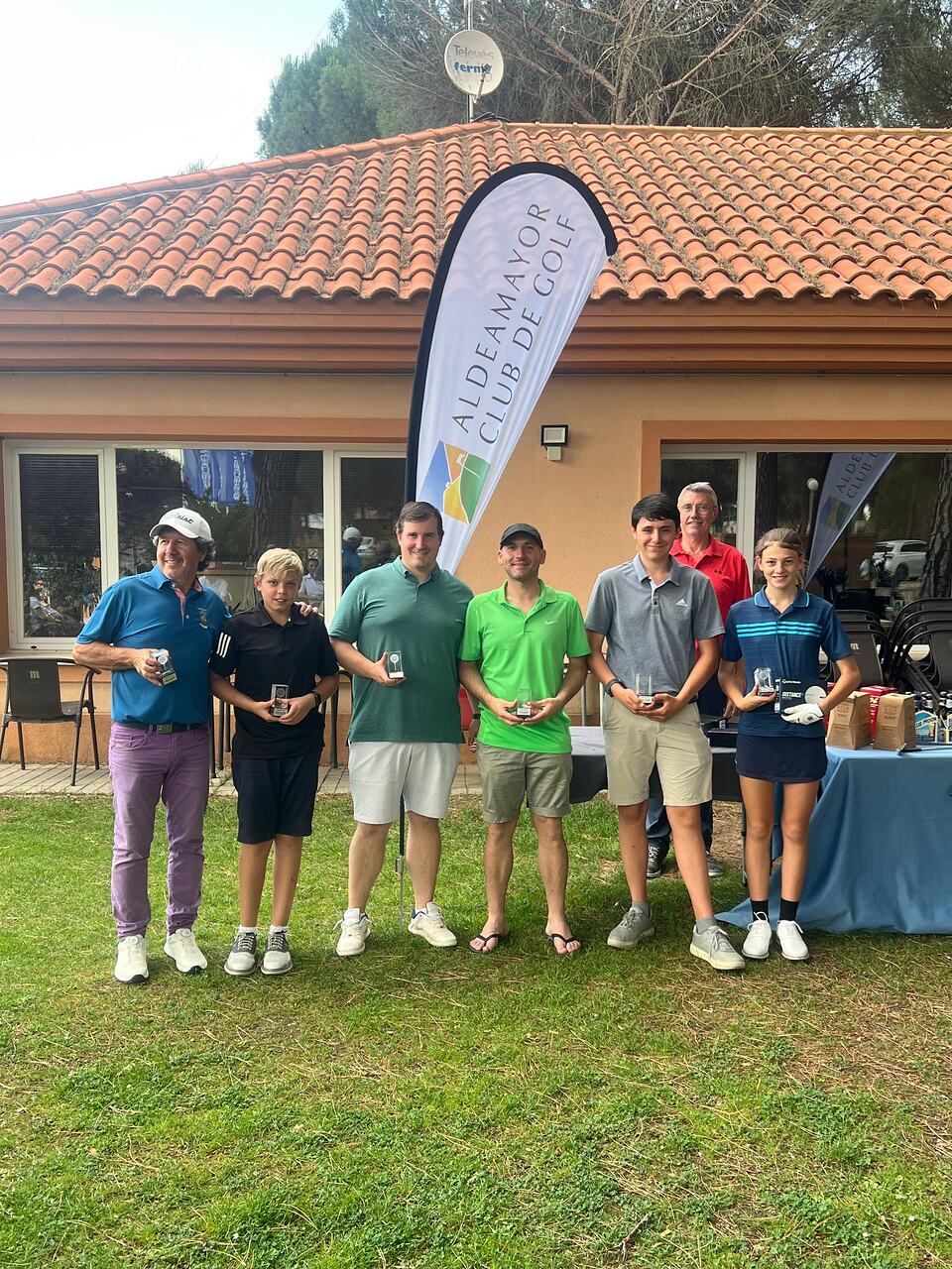 Golfers pose with trophies outside the Aldeamayor Club de Golf clubhouse.