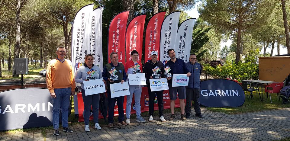 Participants pose with sponsor signs and championship banners at an outdoor golf event.