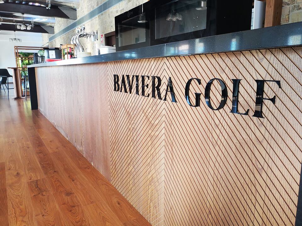 Baviera Golf restaurant counter with a wooden front and the club name in large lettering.