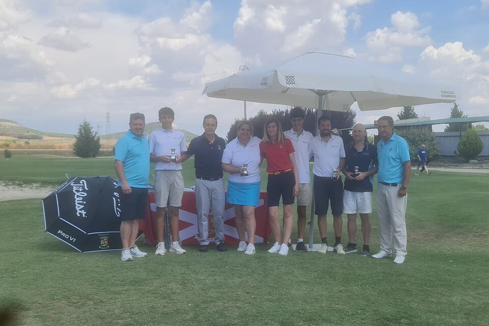 A group of golfers pose with trophies on the course at Aldeamayor Club de Golf.