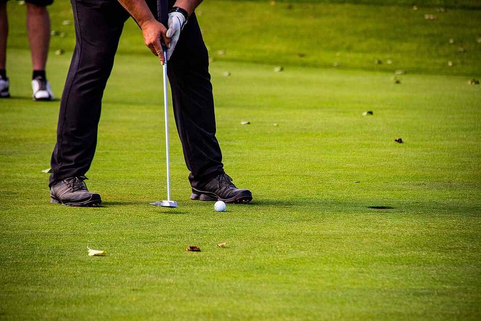 A golfer lines up a putt on a green.